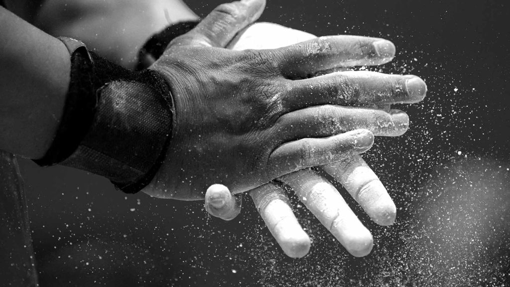 A closeup view of hands applying chalk.