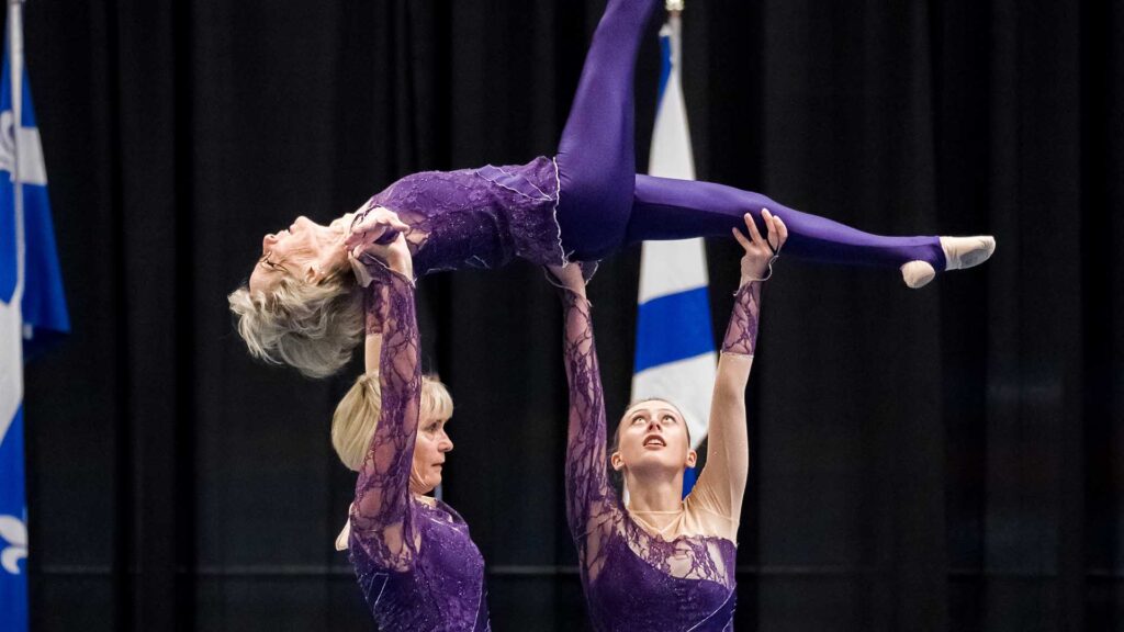 Three female gymnasts compete