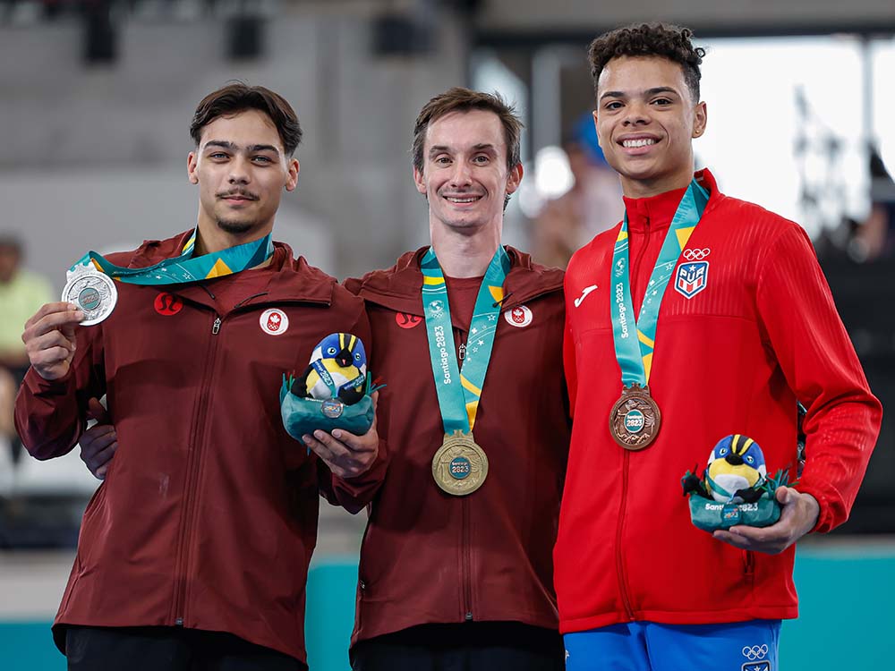 Three Canadian gymnasts display medals earned in Santiago, Chile