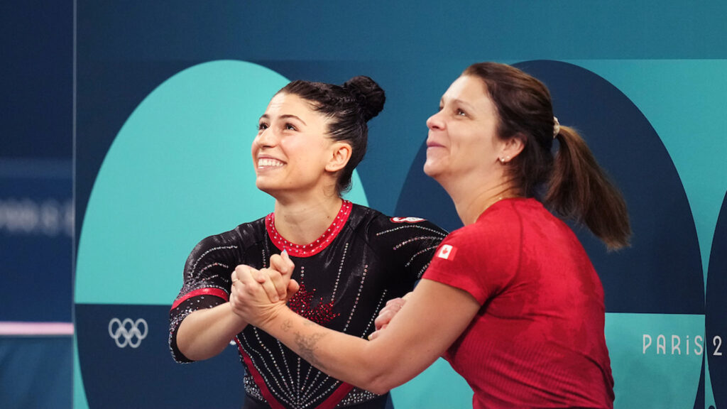 karina Kosko and Sophiane Méthot holding hands and looking up at results